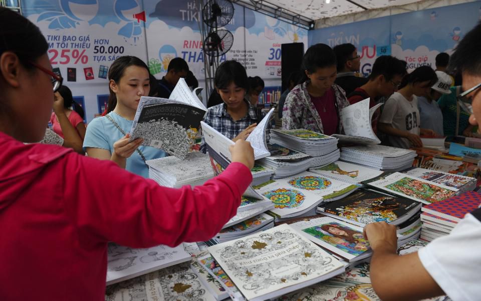 Students look at books during a four-day book fair at a public park in downtown Hanoi on September 11, 2015
